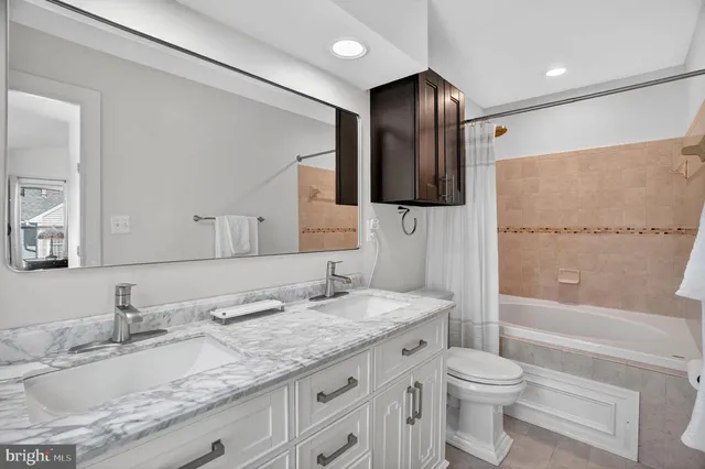 a bathroom with a granite countertop sink a toilet a large mirror and shower