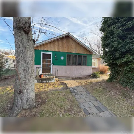 a front view of house with yard and trees around