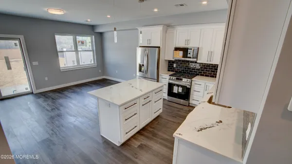 a kitchen with white cabinets and stainless steel appliances