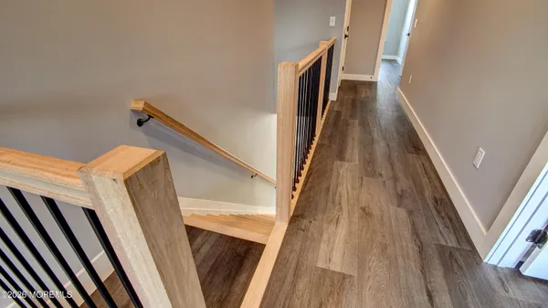a view of a hallway with wooden floor and stairs