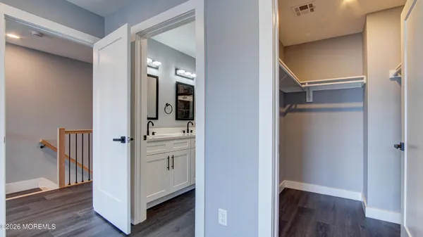 a view of a hallway with closet and wooden floor