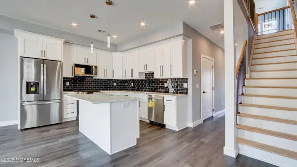 a kitchen with stainless steel appliances a refrigerator sink and microwave