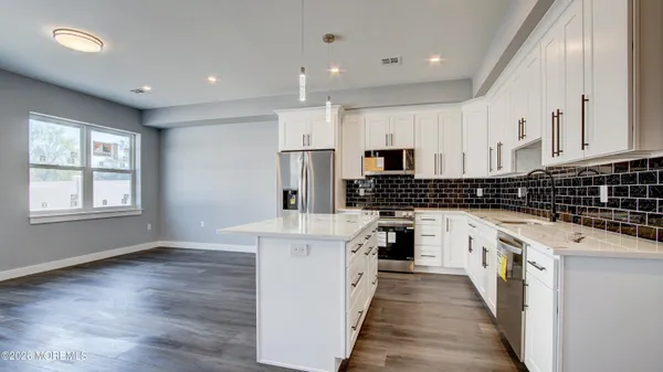 a kitchen with white cabinets sink and stainless steel appliances