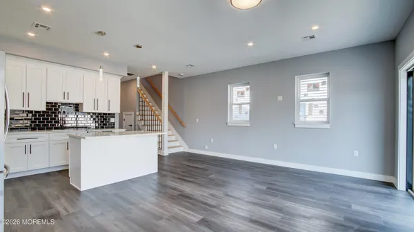 a kitchen with wooden floors and white cabinets
