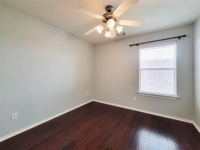 a view of a big room with wooden floor and windows