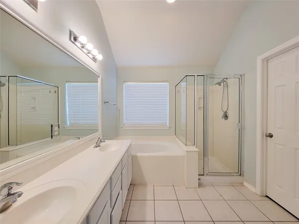 a spacious bathroom with a bathtub a sink and a mirror