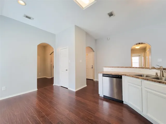 a kitchen with stainless steel appliances granite countertop a sink and wooden floor