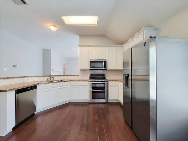 a kitchen with a refrigerator and a stove top oven