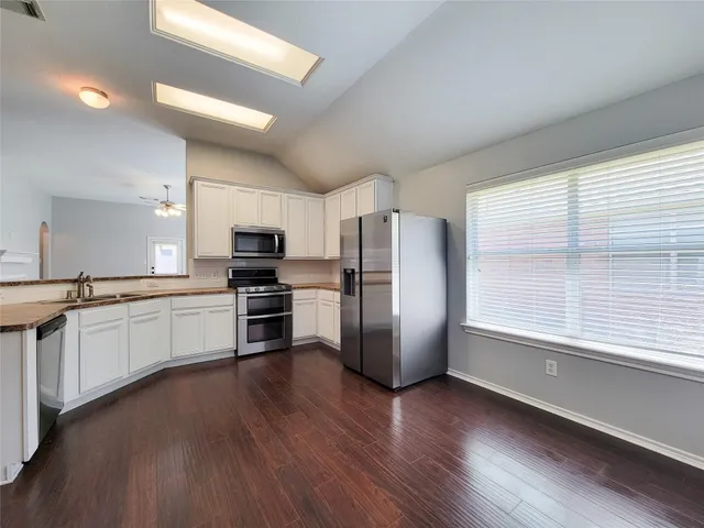 a kitchen with stainless steel appliances a refrigerator and a stove top oven