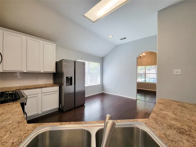 a kitchen with stainless steel appliances granite countertop a refrigerator a stove and a sink with granite countertops