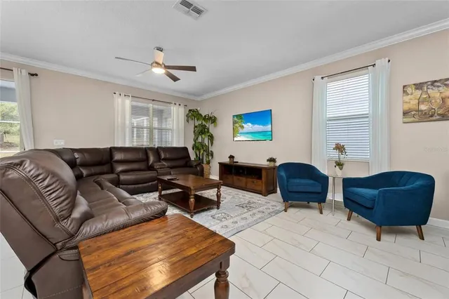 a living room with furniture ceiling fan and a window