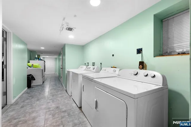 a kitchen with a refrigerator and white cabinets