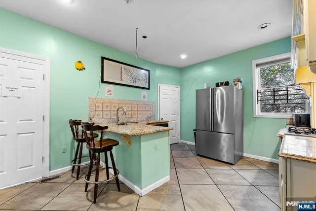 a kitchen with stainless steel appliances granite countertop a refrigerator and a stove top oven