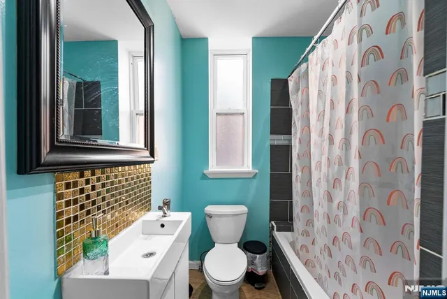 a bathroom with a toilet and a shower curtain