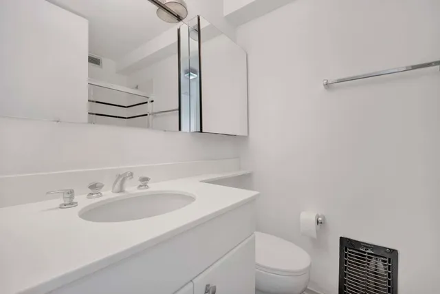 a bathroom with a sink toilet and a mirror