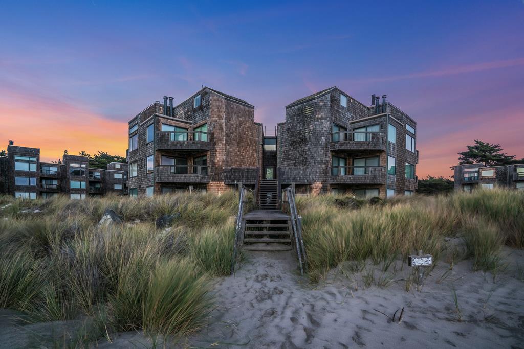 a view of a house with a yard next to a lake