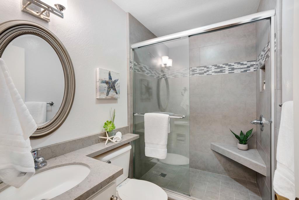 101 Shell Road, Unit 248 Watsonville, CA 95076 - Photo 20 of 28 a bathroom with a sink a mirror a toilet and a shower
