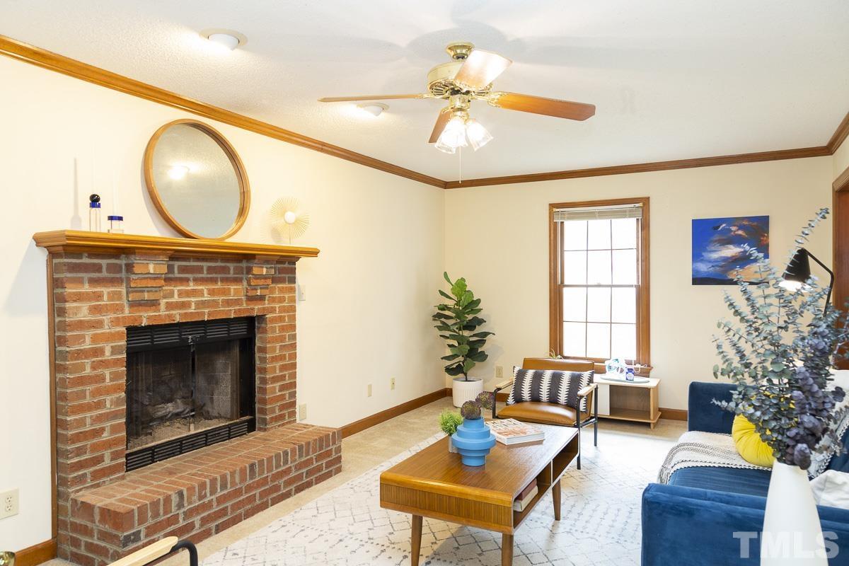 2817 Herring Boulevard Durham, NC 27704 - Photo 7 of 34 a living room with furniture a flat screen tv and a fireplace