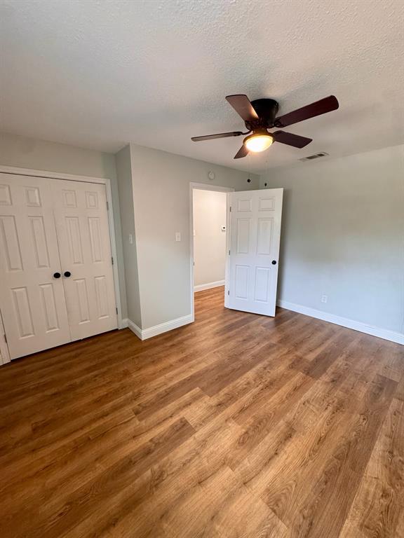 624 East 3rd Street, Unit 202 Springtown, TX 76082 - Photo 6 of 9 Wood-finish flooring, ceiling fan with integrated lighting, paneled doors, and light-toned wall paint