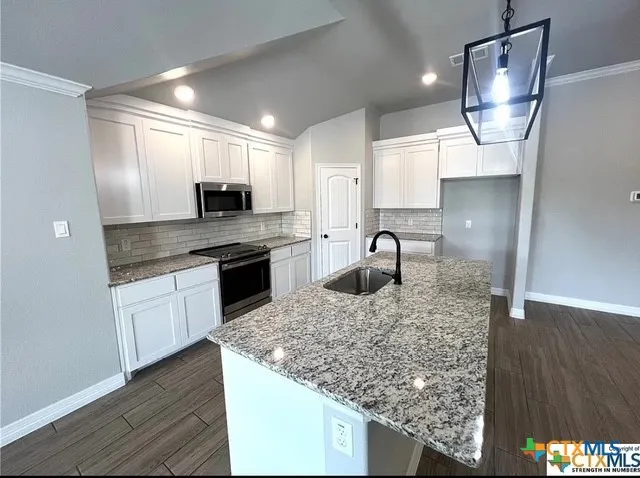 a kitchen with stainless steel appliances granite countertop a sink and a microwave