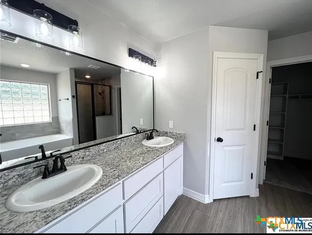 a bathroom with a granite countertop sink double and mirror