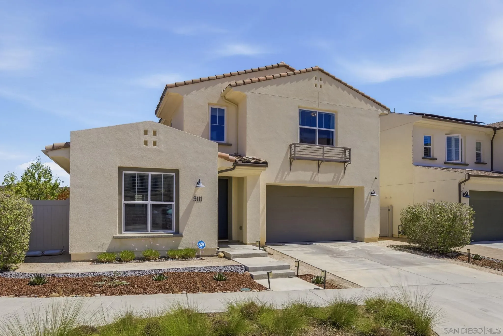 9111 West Bluff Place Santee, CA 92071 - Photo 3 of 36 a front view of a house with a garden and garage