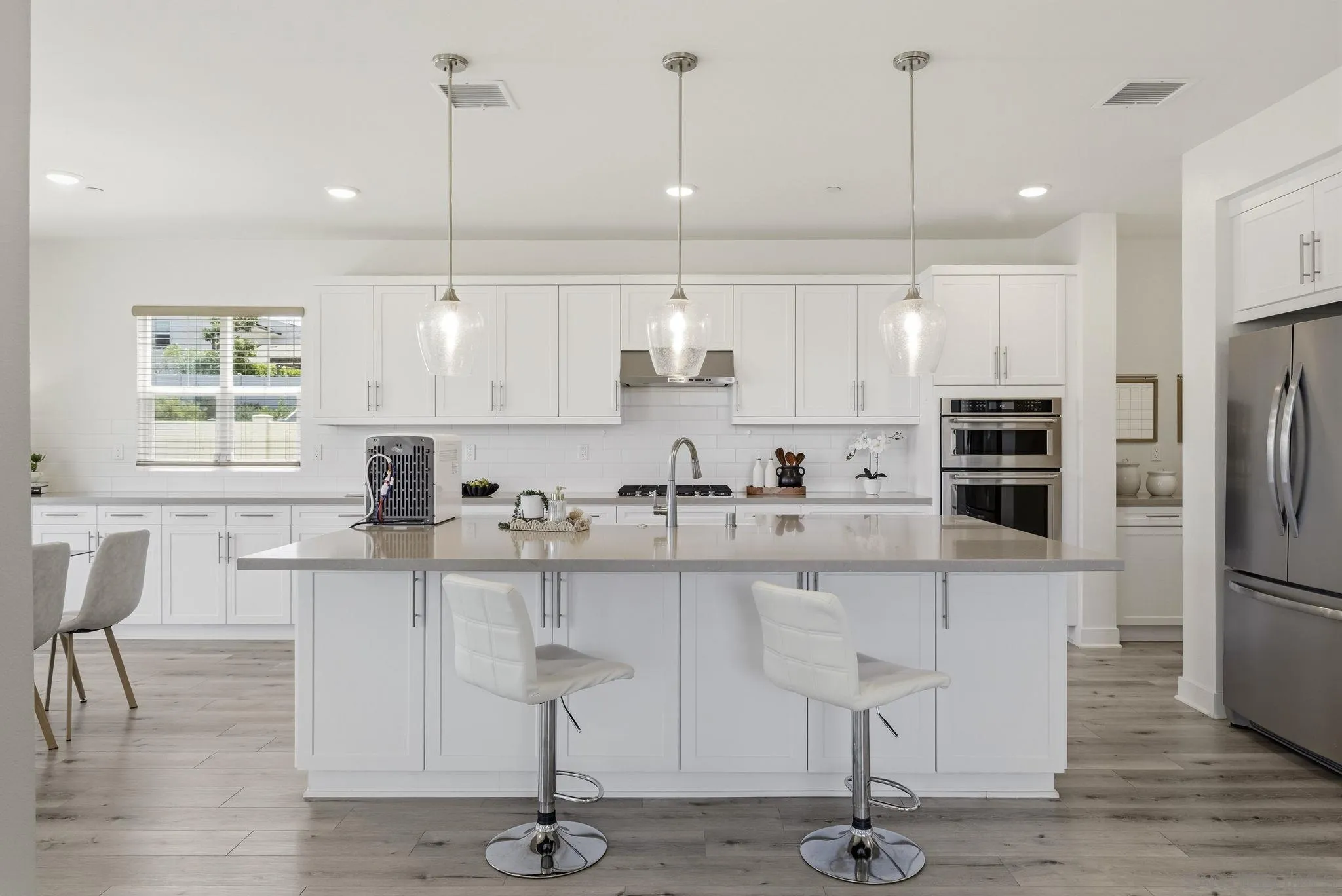 9111 West Bluff Place Santee, CA 92071 - Photo 9 of 36 a kitchen with stainless steel appliances granite countertop a refrigerator a sink dishwasher a stove and white cabinets with wooden floor