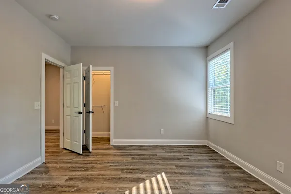 a view of a hallway with wooden floor and entryway