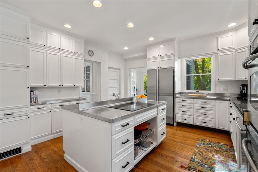 999 Walnut Street Newton, MA 02461 - Photo 14 of 38 a kitchen that has a lot of cabinets in it and wooden floors