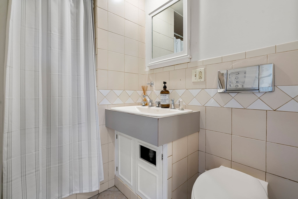 999 Walnut Street Newton, MA 02461 - Photo 17 of 38 a bathroom with a sink toilet and vanity