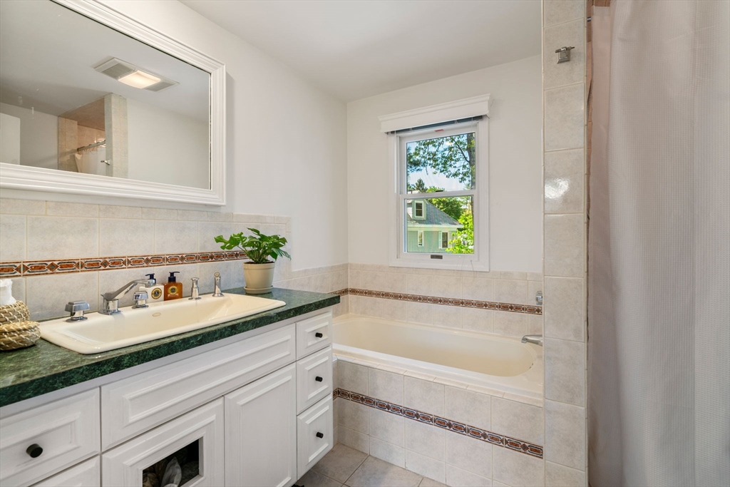 999 Walnut Street Newton, MA 02461 - Photo 24 of 38 a bathroom with a granite countertop tub sink and mirror