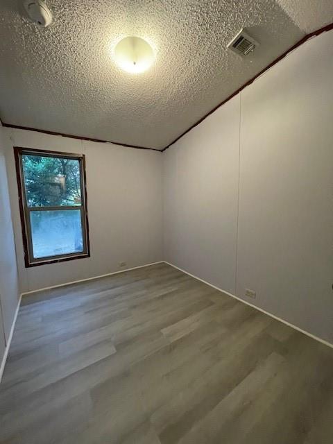 3125 Bois D Arc Road Combine, TX 75159 - Photo 10 of 15 Spare room featuring wood-type flooring and a textured ceiling
