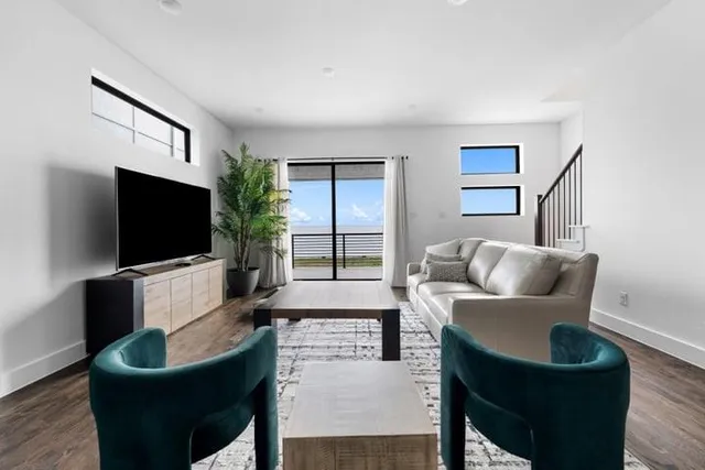 a kitchen with a sink dishwasher a stove and white cabinets with wooden floor