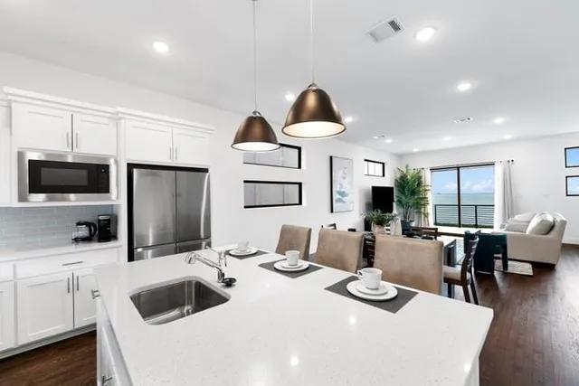 a kitchen with a table chairs sink and cabinets