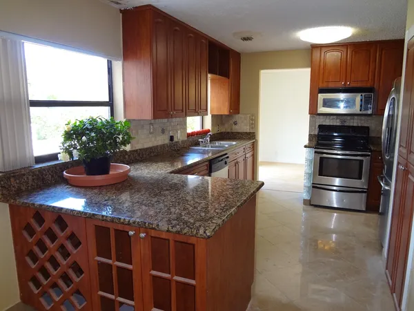 a kitchen with stainless steel appliances granite countertop a sink stove and refrigerator