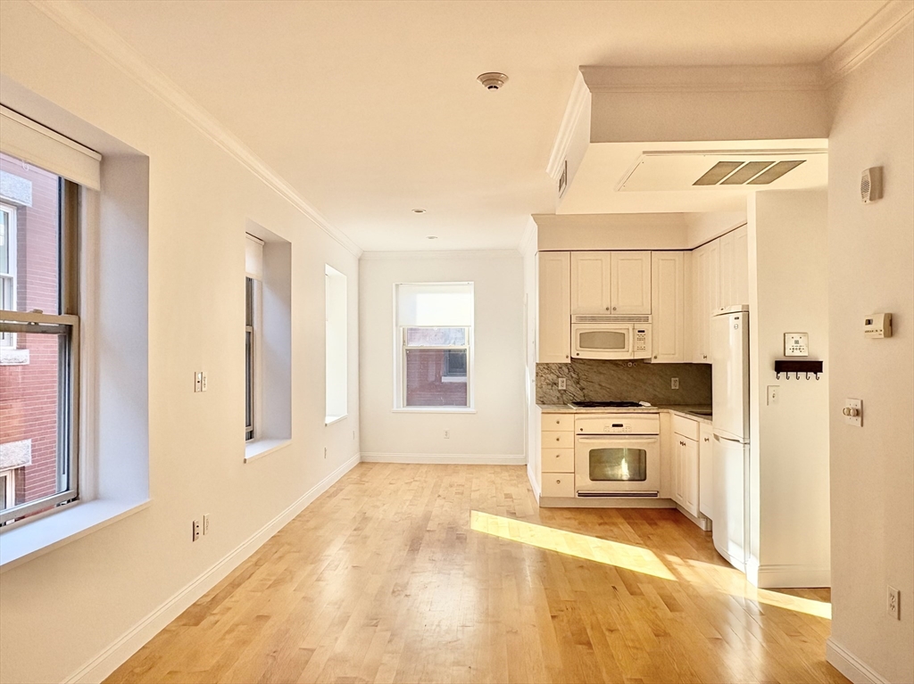 11 Unity Street, Unit 8 Boston, MA 02113 - Photo 3 of 20 a view of a kitchen with a stove cabinets and a wooden floor