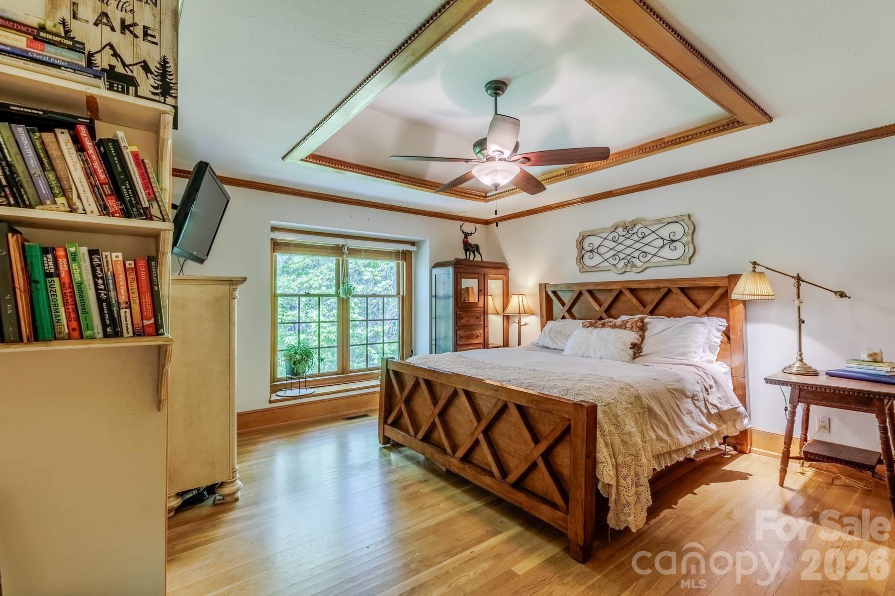 97 Covered Bridge Road Robbinsville, NC 28771 - Photo 19 of 45 a bedroom with a bed a large window and book shelf