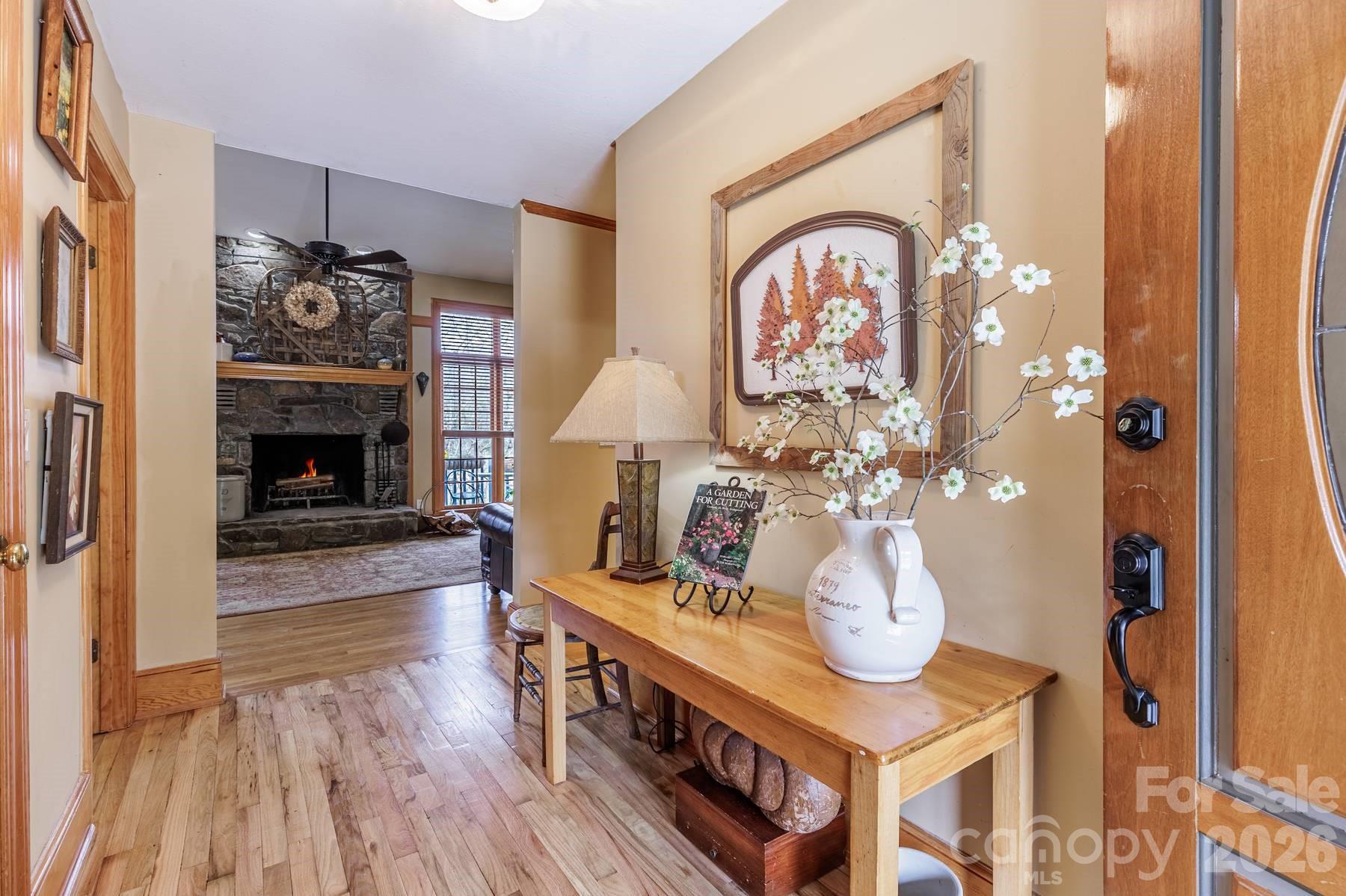 97 Covered Bridge Road Robbinsville, NC 28771 - Photo 2 of 45 a living room with furniture a fireplace and a chandelier