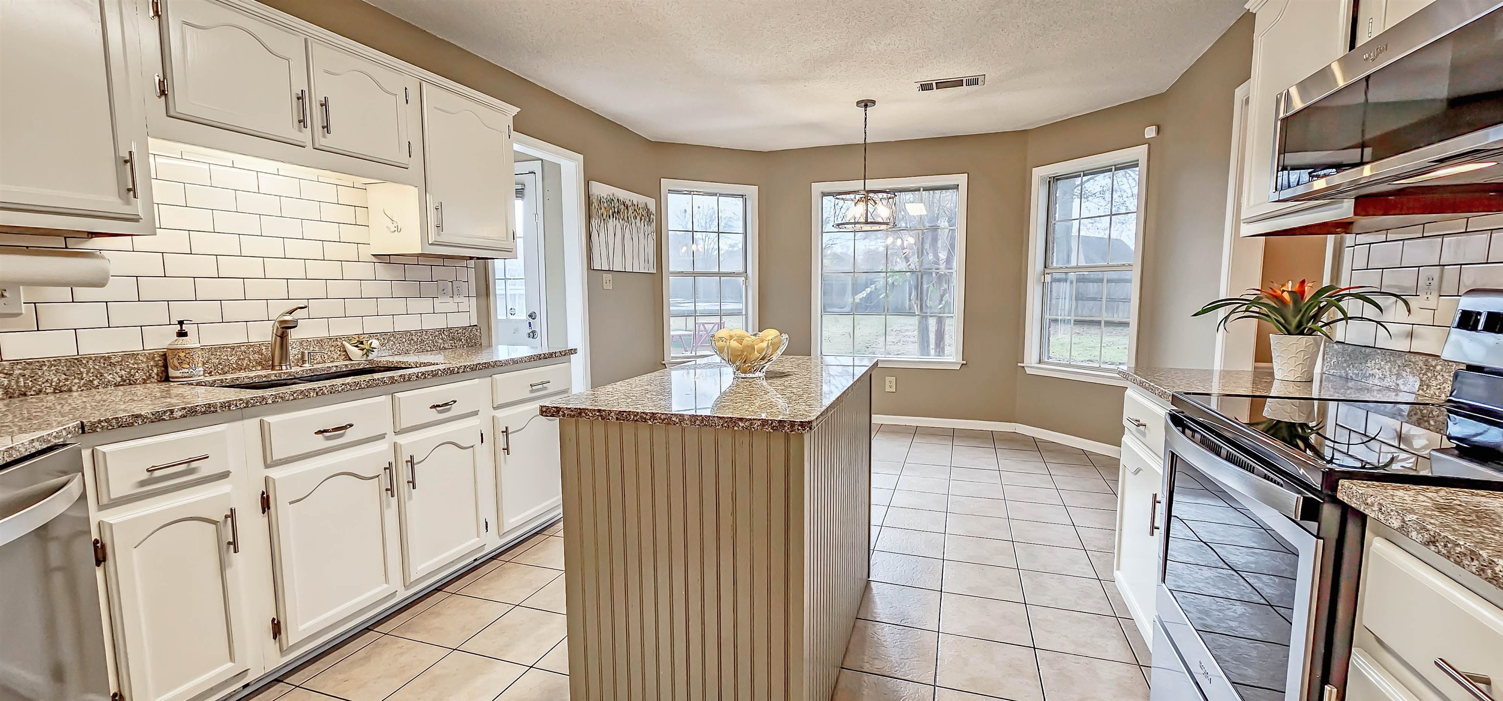 251 Summit View Cove Collierville, TN 38017 - Photo 15 of 30 a kitchen with stainless steel appliances granite countertop a sink stove and cabinets