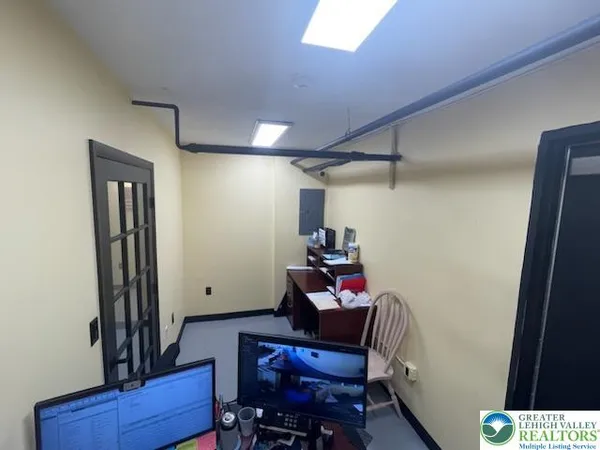 a view of a hallway with workspace and a couch