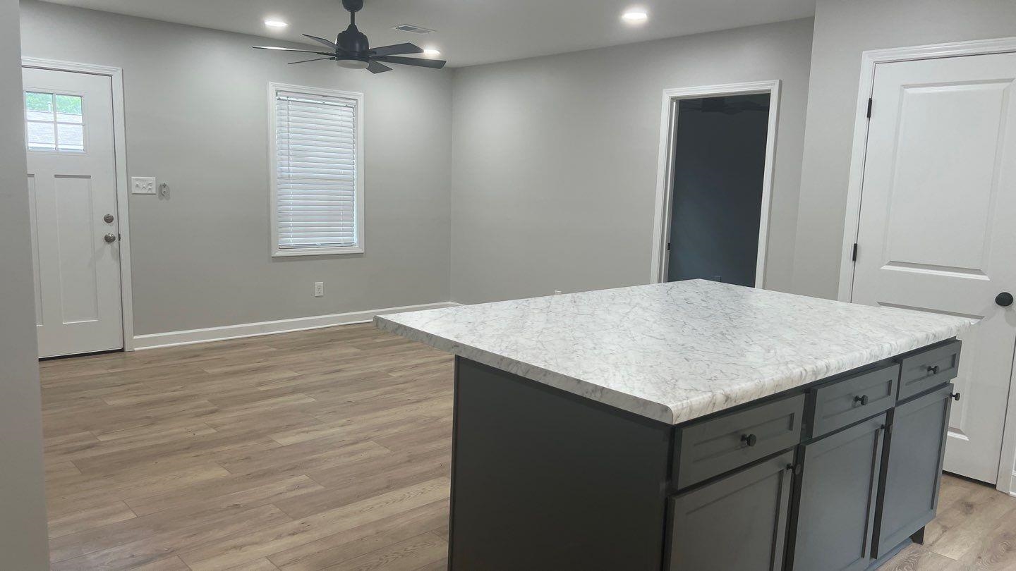 4411 Helene Road Memphis, TN 38117 - Photo 3 of 13 an empty room with wooden floor cabinet and windows