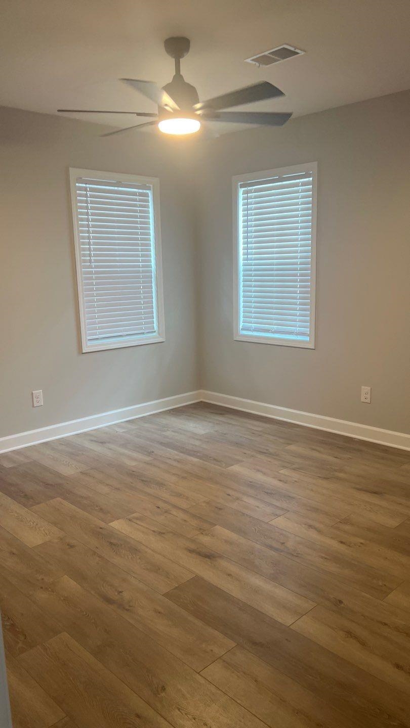 4411 Helene Road Memphis, TN 38117 - Photo 5 of 13 an empty room with wooden floor chandelier fan and windows