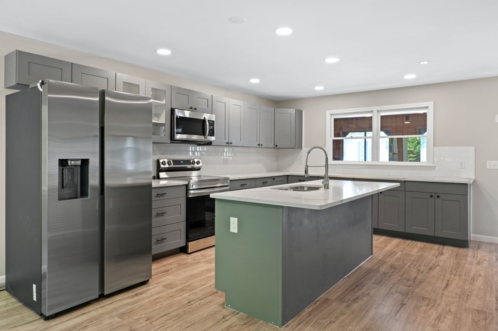 549 Main Street Townsend, MA 01474 - Photo 8 of 41 a kitchen with kitchen island granite countertop a sink refrigerator and microwave