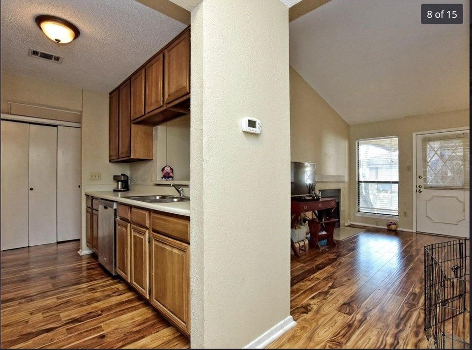 806 West 24th Street, Unit 331 Austin, TX 78705 - Photo 3 of 12 a kitchen with stainless steel appliances granite countertop a stove top oven a sink dishwasher and a refrigerator with wooden floor