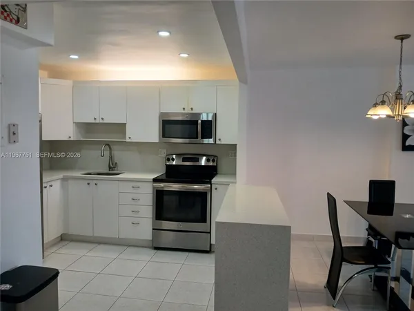 a kitchen with a stove a sink and a refrigerator