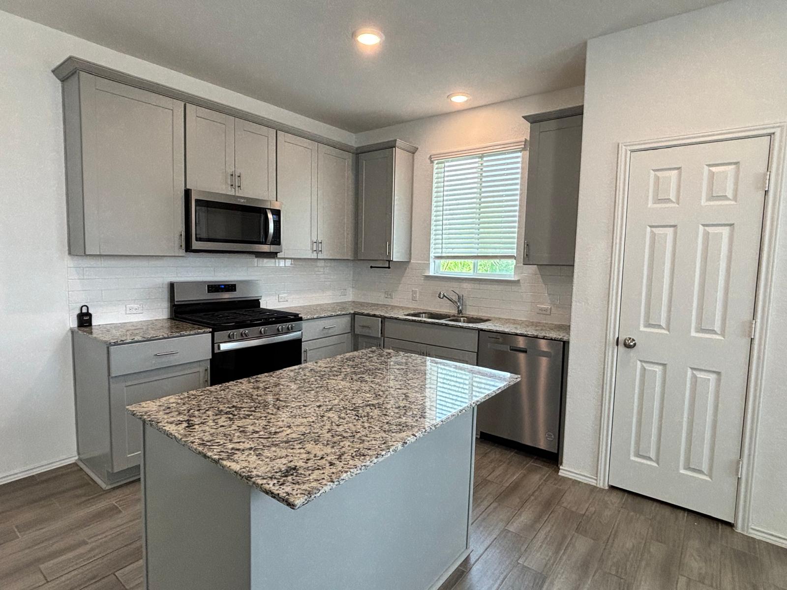 1509 Hope Rnch Road Leander, TX 78641 - Photo 8 of 25 Kitchen featuring stainless steel appliances, gray cabinets, a sink, dark wood-type flooring, and recessed lighting