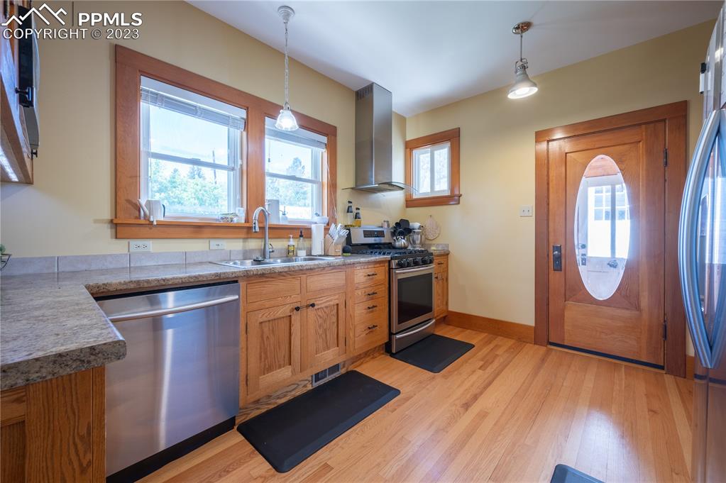 24141 Eccles Street Elbert, CO 80106 - Photo 22 of 37 a kitchen with stainless steel appliances granite countertop wooden floors and sink