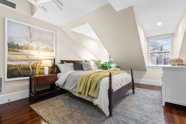 a bedroom with a bed wooden floor and window