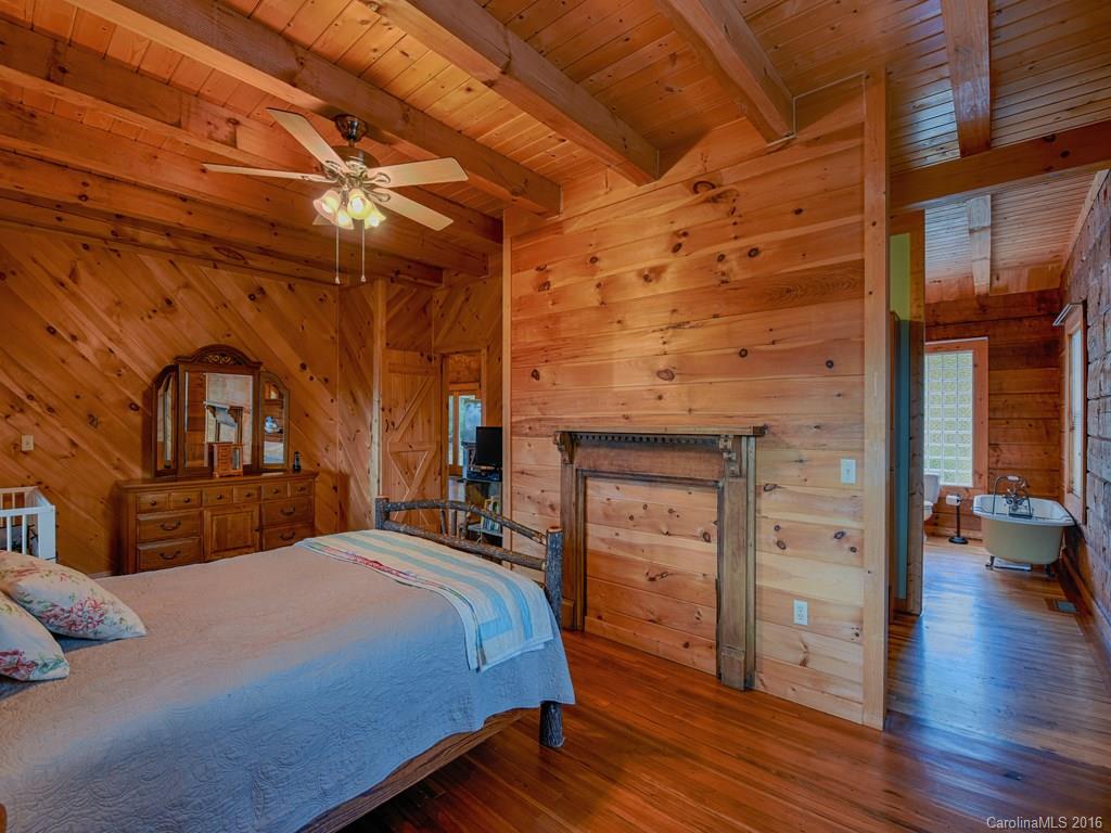 334 Ridgeview Lane Canton, NC 28716 - Photo 17 of 24 a bedroom with a bed and a chandelier