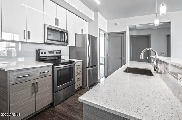 a kitchen with appliances a sink cabinets and a window
